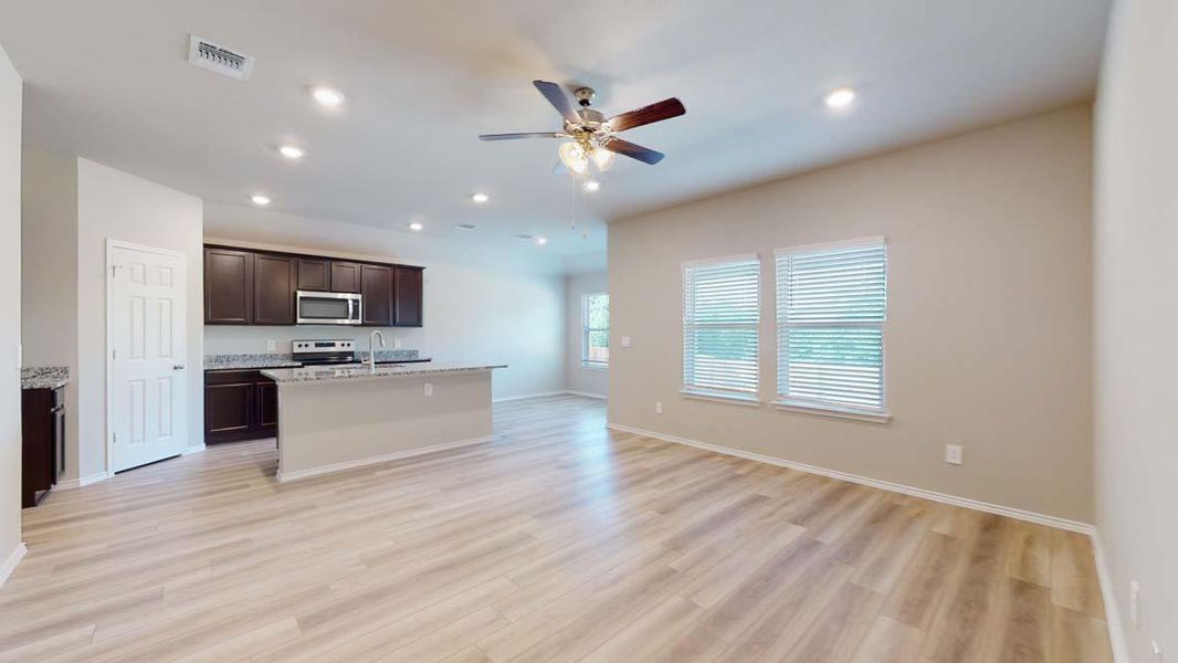 Open-concept living area featuring wood-finish flooring, recessed lighting, and a ceiling fan