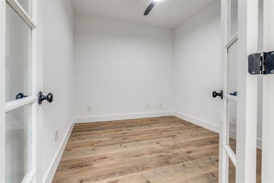 Study room with ceiling fan, light wood finished floors, and baseboards