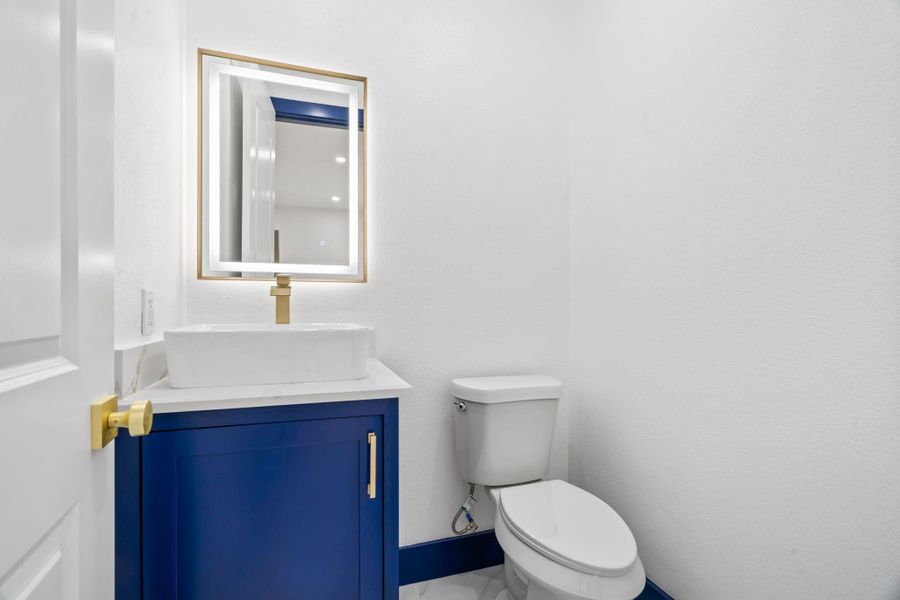 This half bath features gold fixtures, adding a refined touch of luxury. This half bath features gold fixtures, adding a refined touch of luxury.