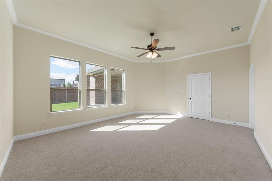 Unfurnished room featuring ceiling fan, light colored carpet, and ornamental molding