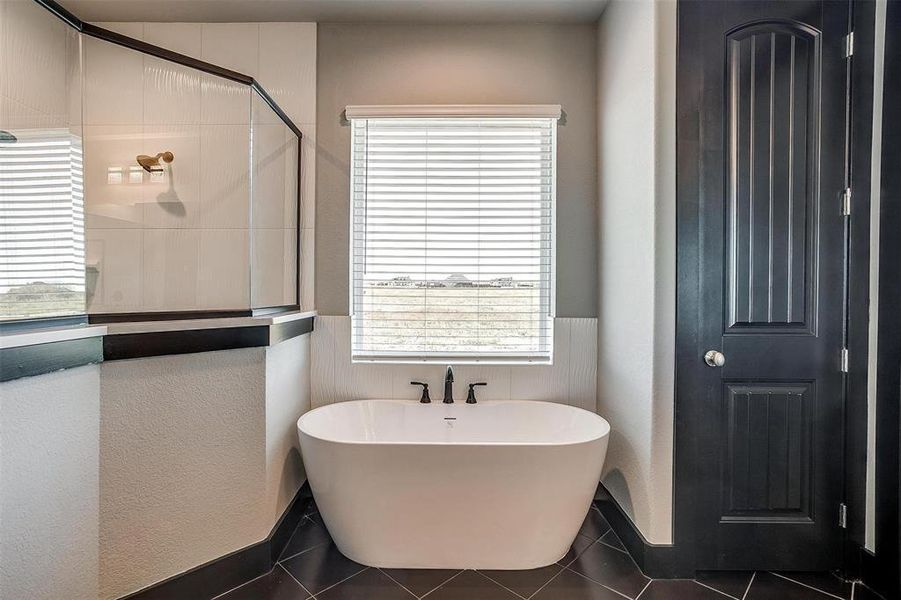 Bathroom with tile patterned flooring, a healthy amount of sunlight, and plus walk in shower