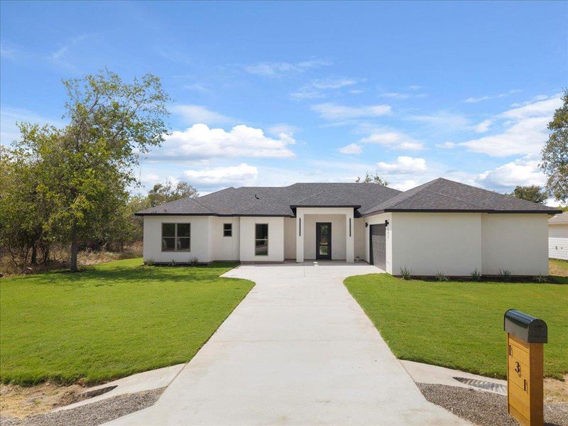 View of front of property featuring a shingled roof, concrete driveway, an attached garage, a front lawn, and stucco siding View of front of property featuring a shingled roof, concrete driveway, an attached garage, a front lawn, and stucco siding