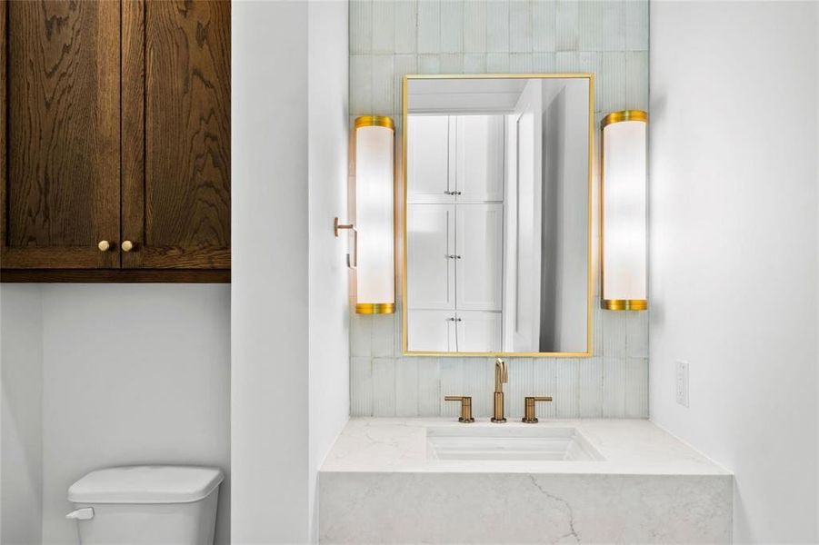 Half bath featuring vanity and backsplash Half bath featuring vanity and backsplash