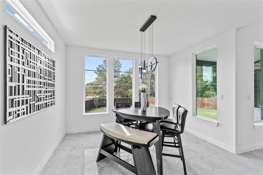 Dining space featuring a chandelier and light marble finish flooring