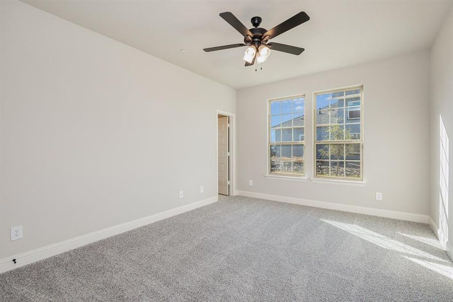 Carpeted empty room featuring ceiling fan