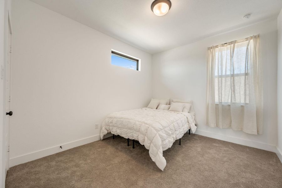 A well-lit room with soft carpet and a modern ceiling fixture. A well-lit room with soft carpet and a modern ceiling fixture.