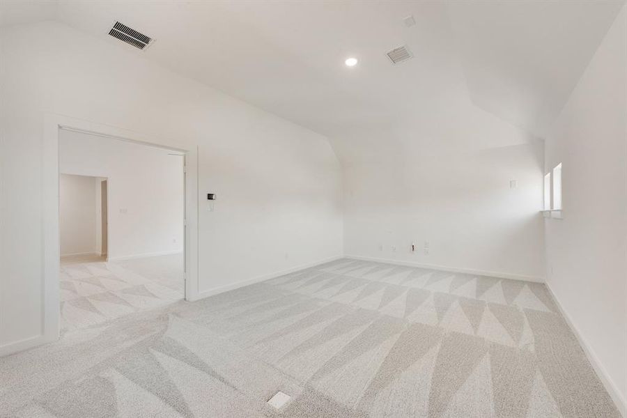 Spare room with vaulted ceiling, light carpet, and recessed lighting Spare room with vaulted ceiling, light carpet, and recessed lighting