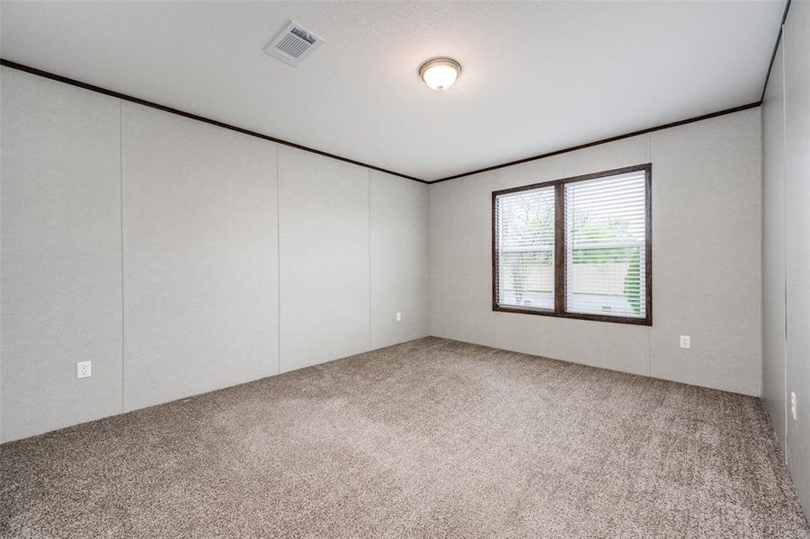 Unfurnished room featuring light carpet, crown molding, and a decorative wall Unfurnished room featuring light carpet, crown molding, and a decorative wall