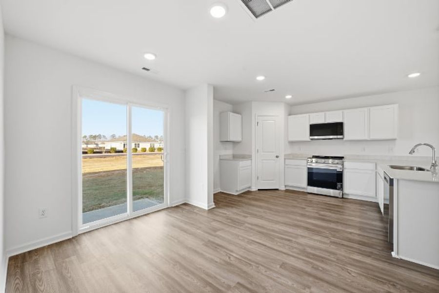 A kitchen with white cabinets.