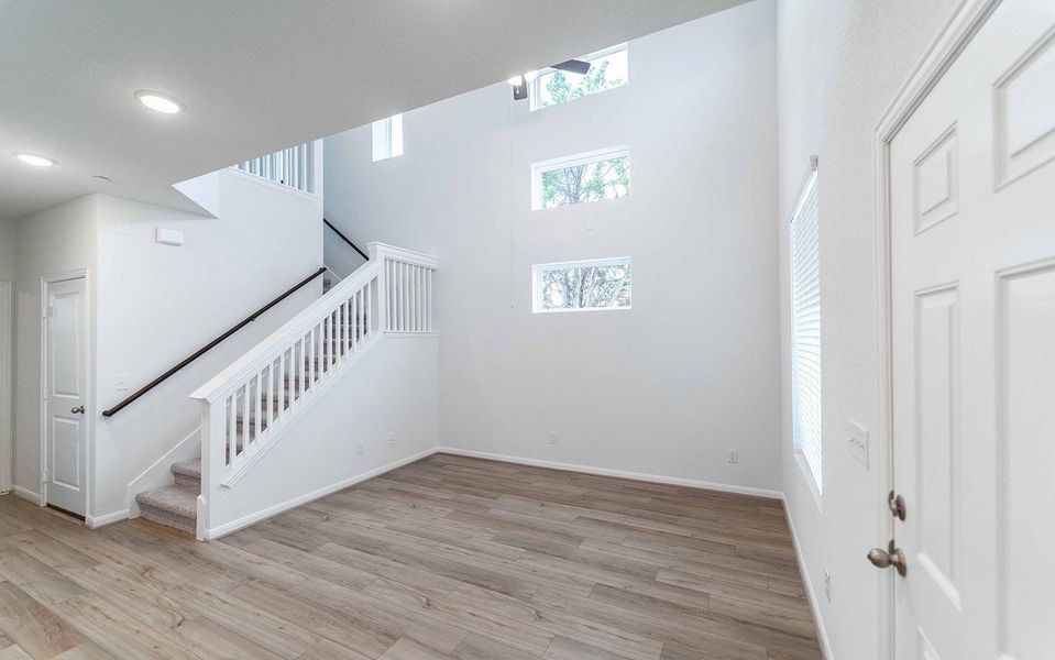 Stairs with a high ceiling and wood finished floors