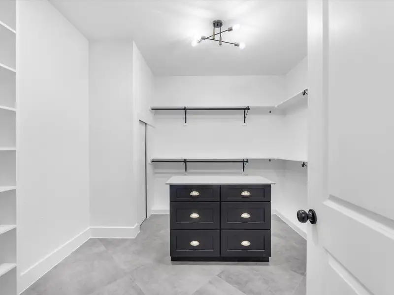 Wow, this closet is a dream come true. You have endless storage and an island with drawers to store jewlery, ties, watches.