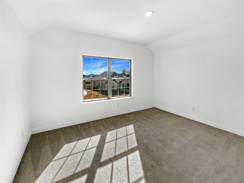 Carpeted empty room with lofted ceiling, recessed lighting, and baseboards