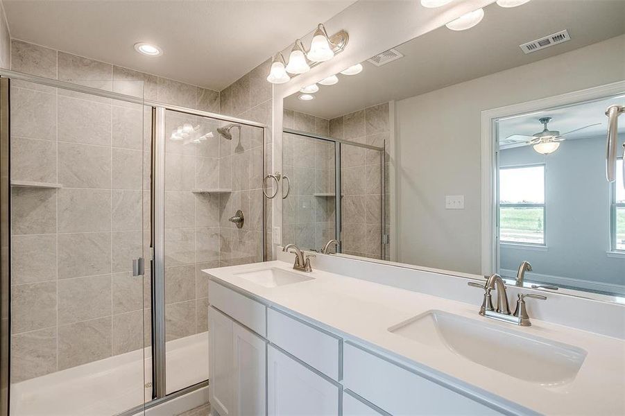 Bathroom featuring double vanity, a stall shower, recessed lighting, and ceiling fan