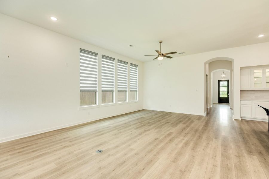 Spacious open-concept living area featuring a seamless flow from the front entryway into the combined family room and dining space, ideal for entertaining and hosting guests.