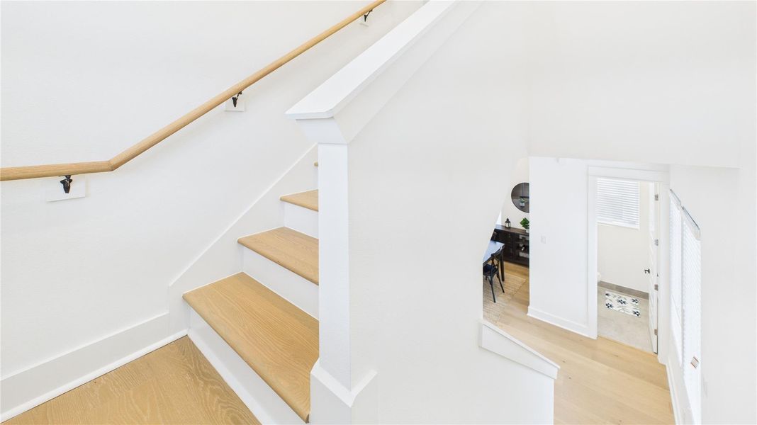 The staircase connecting the second and third floors features a clean design, providing a seamless transition between levels while complementing the home’s style.