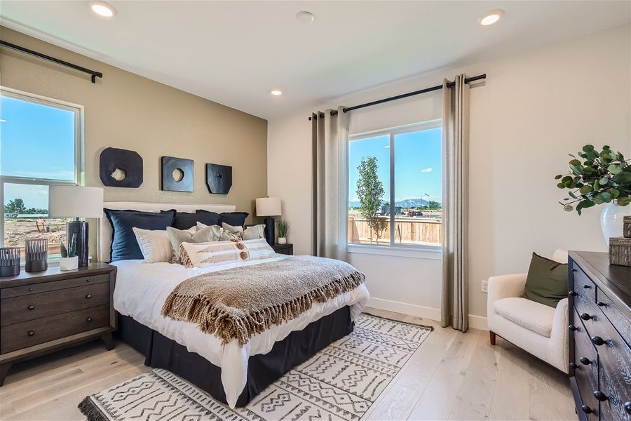 A bedroom with a large window. A bedroom with a large window.