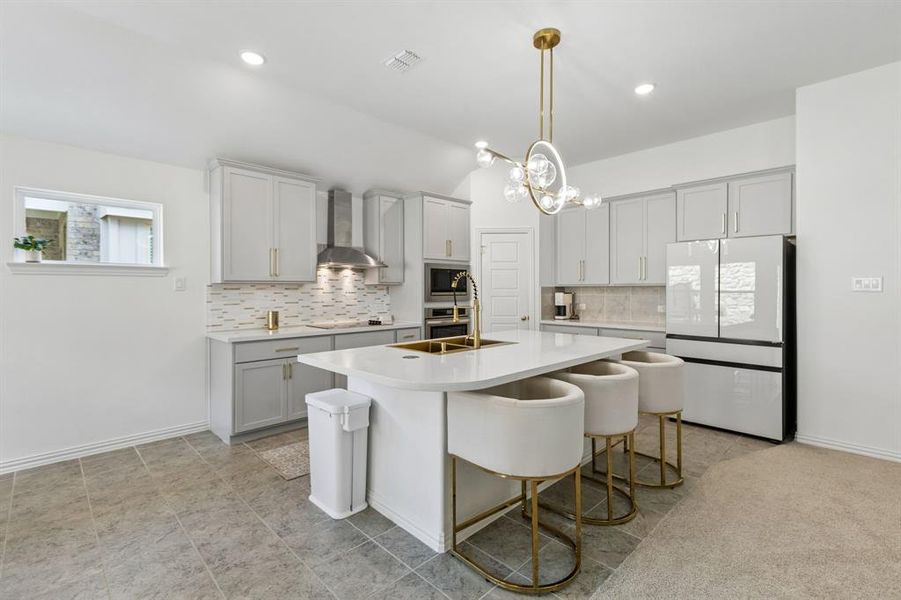 Modern kitchen featuring a white countertop island, pendant lighting, built-in stainless steel appliances, light gray cabinetry, and a subway tile backsplash