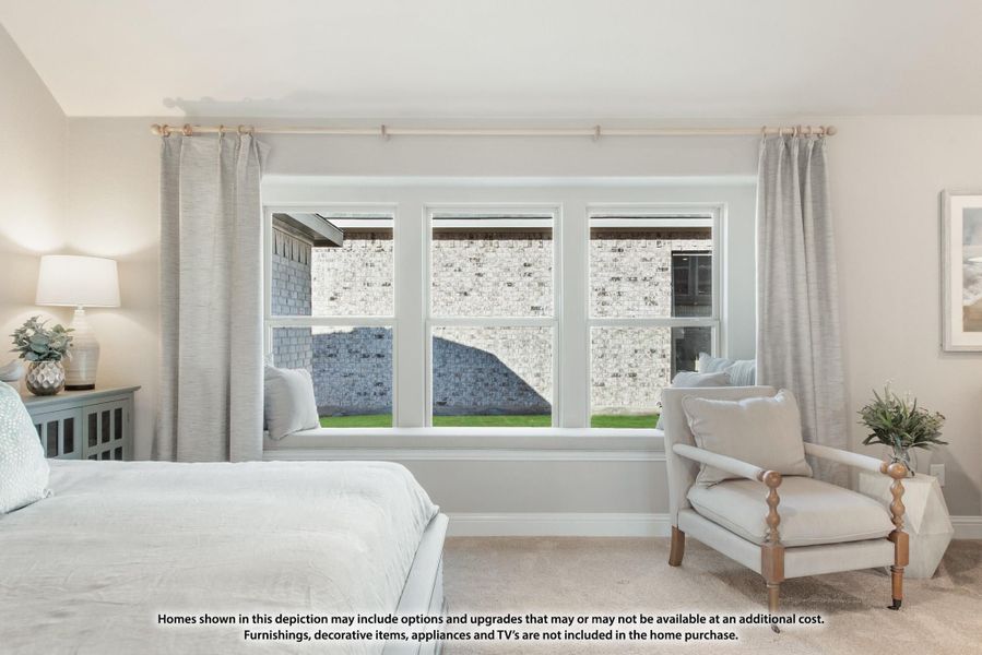 Bedroom with triple window, built-in window seat, gray curtains, and accent chair on carpet