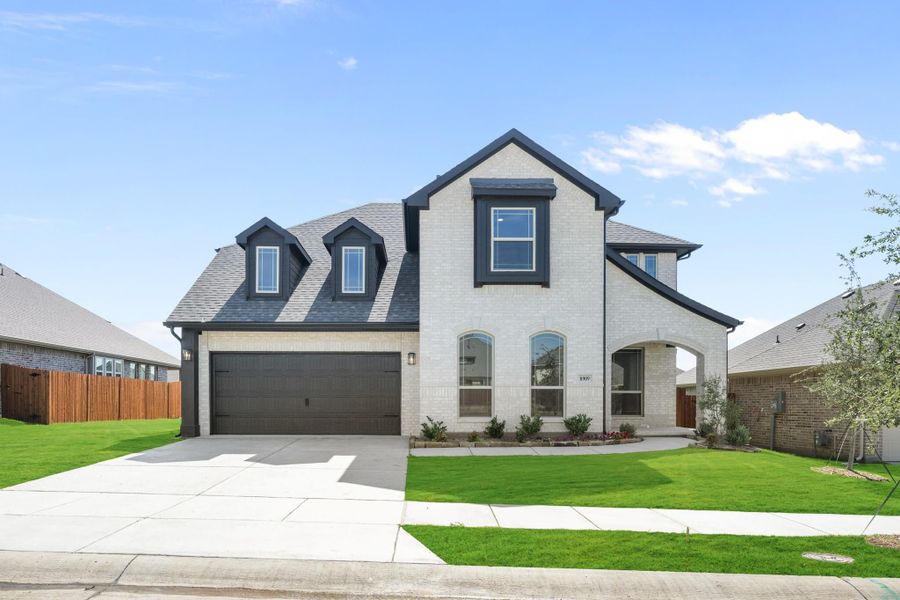 Two-story white brick home with dark roof, two-car garage, and manicured front lawn Two-story white brick home with dark roof, two-car garage, and manicured front lawn