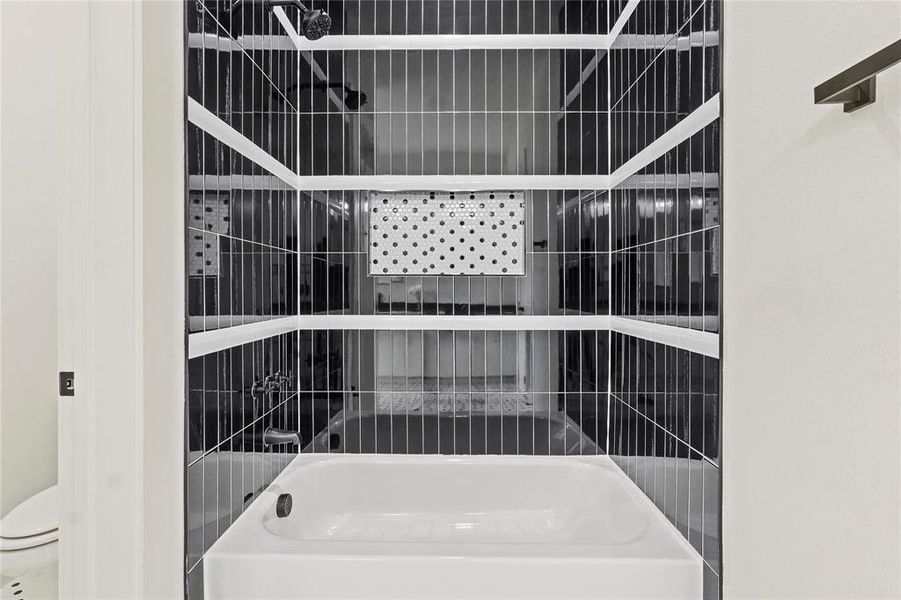 Bathroom featuring washtub / shower combination and toilet Bathroom featuring washtub / shower combination and toilet