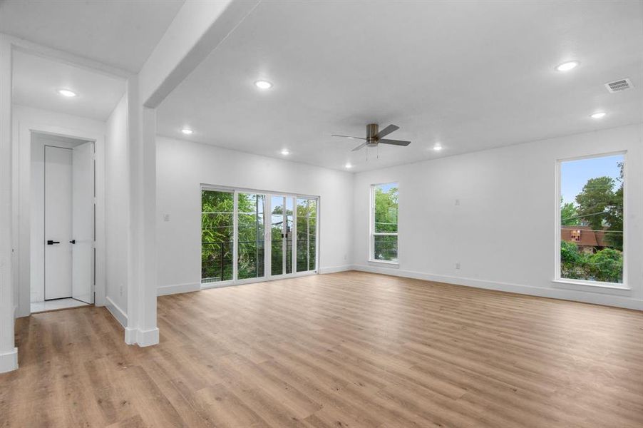 Empty room with light hardwood / wood-style floors and ceiling fan