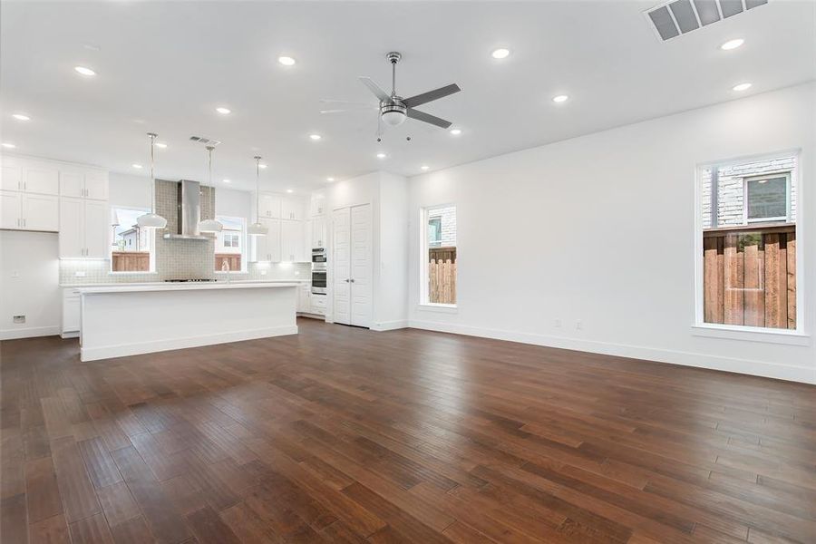 Unfurnished living room with dark hardwood / wood-style floors, sink, and ceiling fan