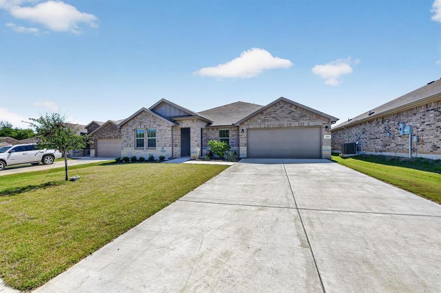 Stone and brick facade home featuring an attached garage and a concrete driveway