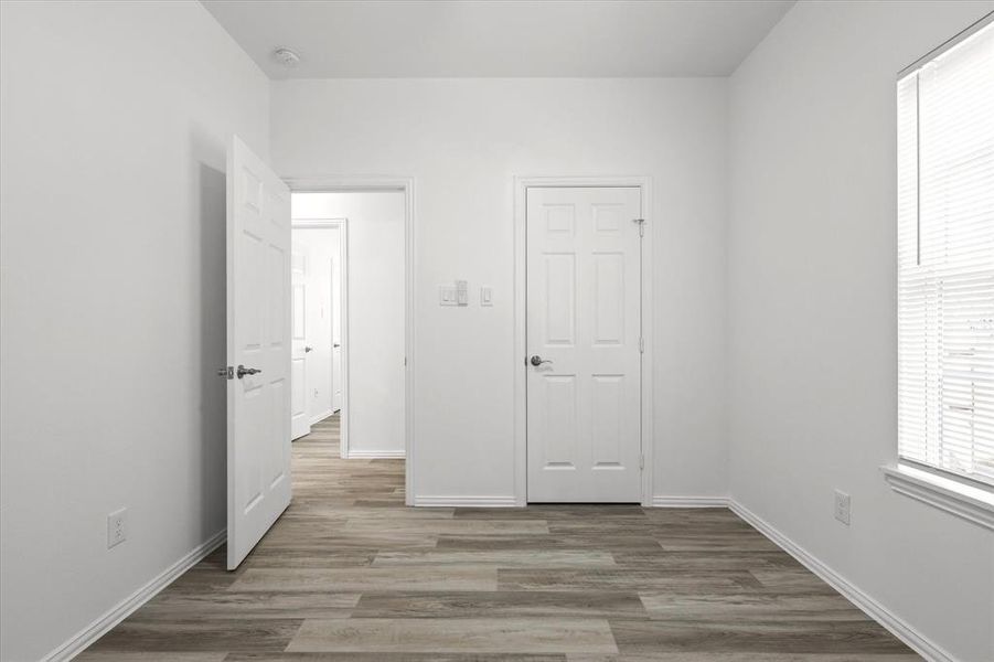 Unfurnished bedroom featuring baseboards and wood finished floors