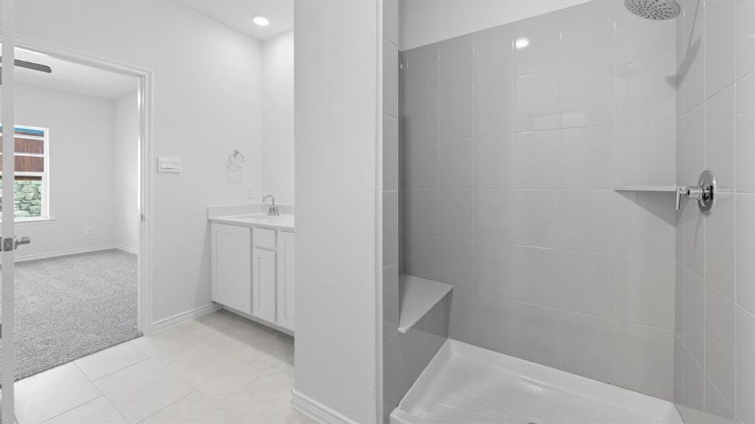 Full bathroom with vanity, light colored carpet, tiled shower, and light tile patterned flooring Full bathroom with vanity, light colored carpet, tiled shower, and light tile patterned flooring