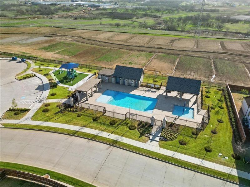 View of the community pool, kiddie pool with splash feature, multiple covered patio areas for shade, and a large shaded playground!