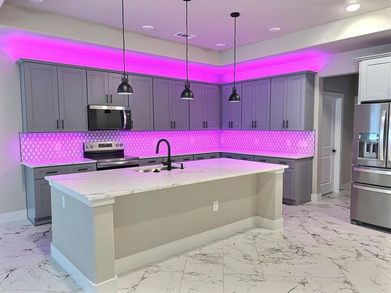 Kitchen with decorative backsplash, stainless steel appliances, light marble finish flooring, light stone counters, and recessed lighting