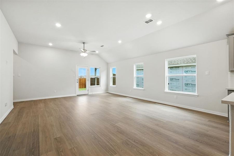 Unfurnished living room with light wood-style floors, vaulted ceiling, recessed lighting, and a ceiling fan Unfurnished living room with light wood-style floors, vaulted ceiling, recessed lighting, and a ceiling fan