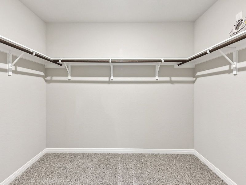 This large primary bedroom closet provides plenty of space for clothes and storage.