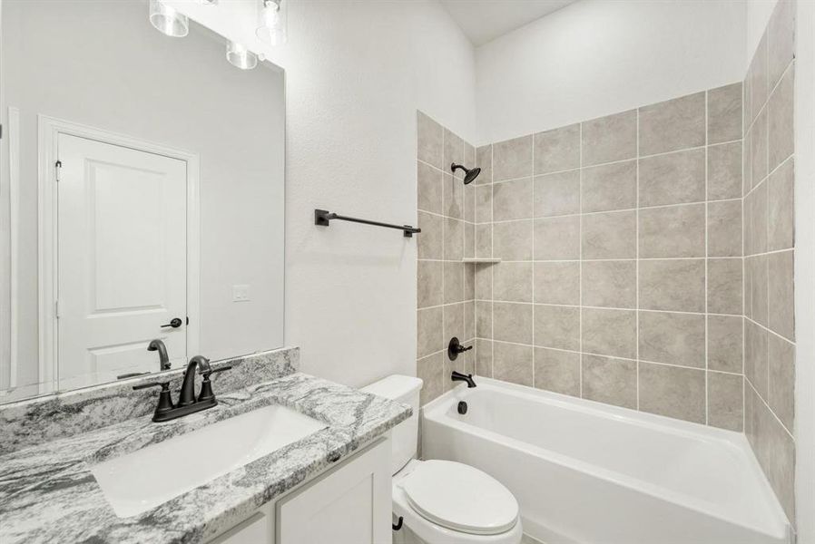 Bathroom featuring a white vanity with a patterned countertop, an undermount sink, and a dark bronze faucet Bathroom featuring a white vanity with a patterned countertop, an undermount sink, and a dark bronze faucet