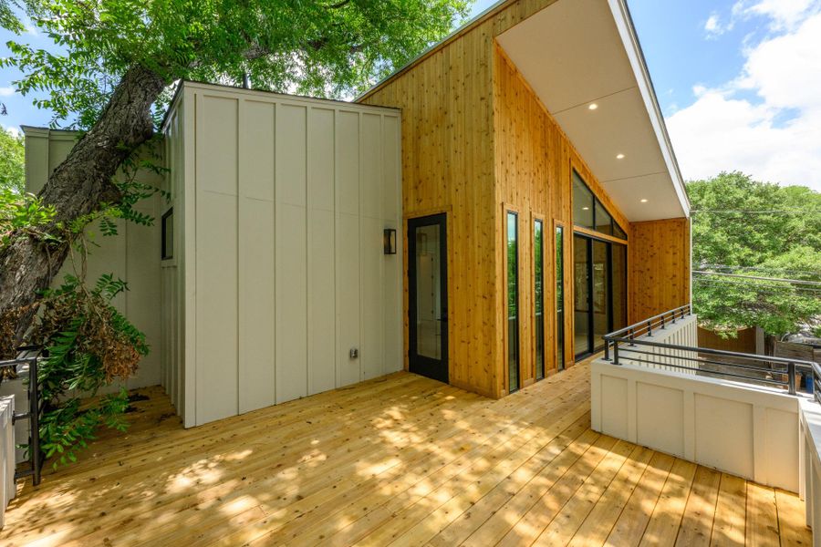 An inviting exterior deck with wooden planks provides seamless indoor-outdoor access through tall glass doors. An inviting exterior deck with wooden planks provides seamless indoor-outdoor access through tall glass doors.