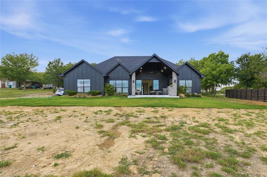 Contemporary architecture featuring dark vertical siding and a black shingle roof