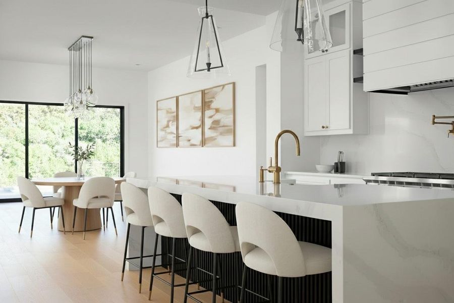 Spacious kitchen featuring a large waterfall-edge island with seating, a brass-finish faucet, and coordinating hardware