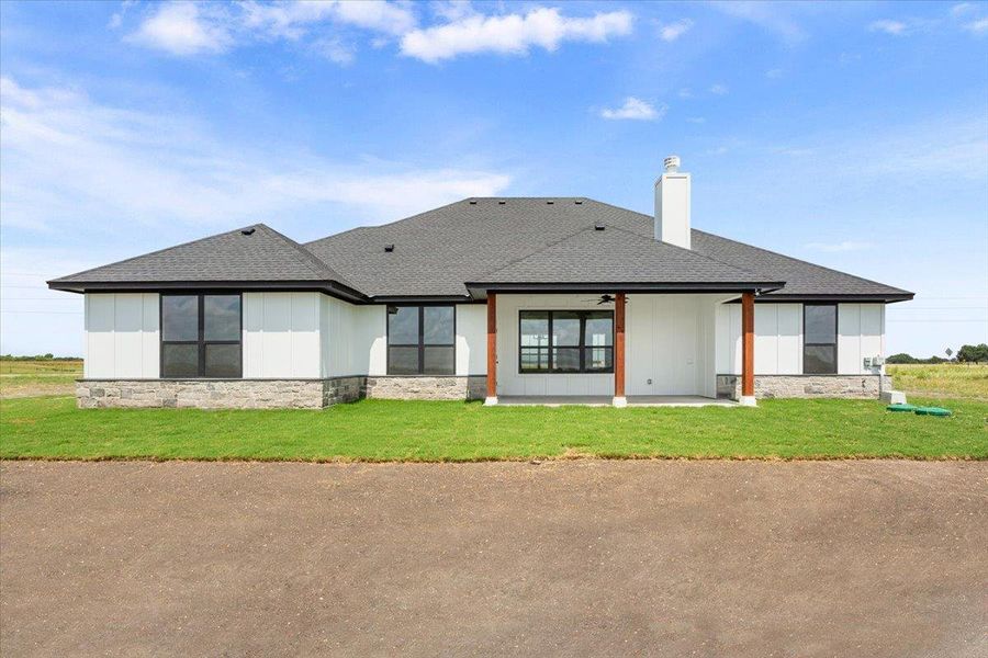 A well-maintained lawn and stone facade enhance the curb appeal of this modern residence.