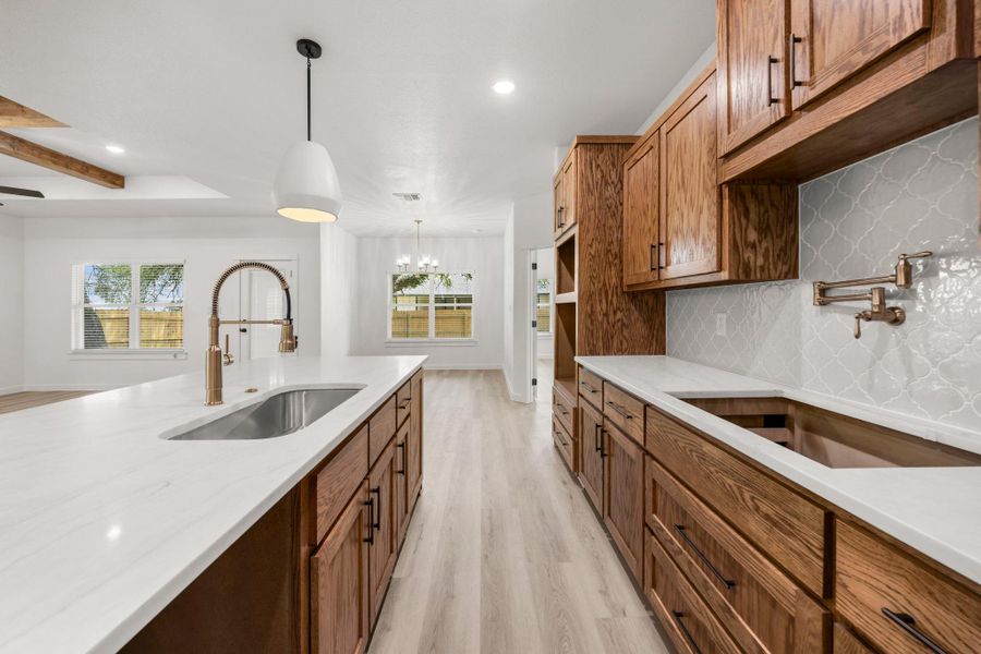 Culinary adventures await in this naturally illuminated kitchen, featuring a spacious island and rich wood cabinetry. Culinary adventures await in this naturally illuminated kitchen, featuring a spacious island and rich wood cabinetry.