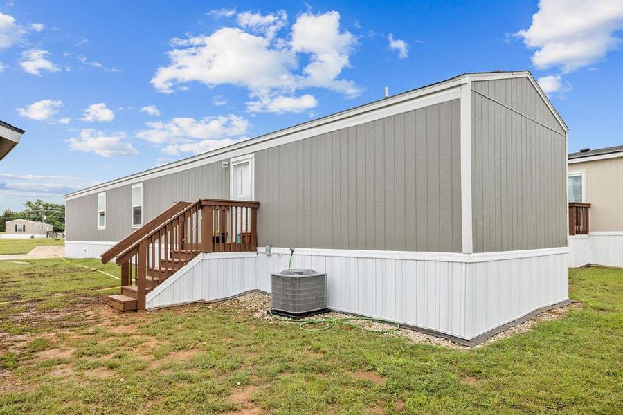 Gray manufactured home featuring white trim and a white foundation skirting Gray manufactured home featuring white trim and a white foundation skirting