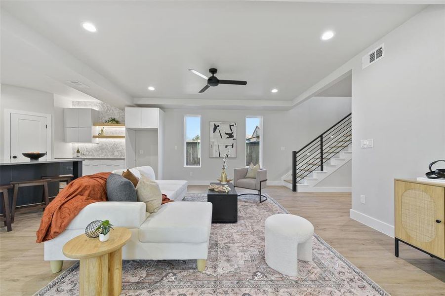 Living room with ceiling fan and light hardwood / wood-style floors