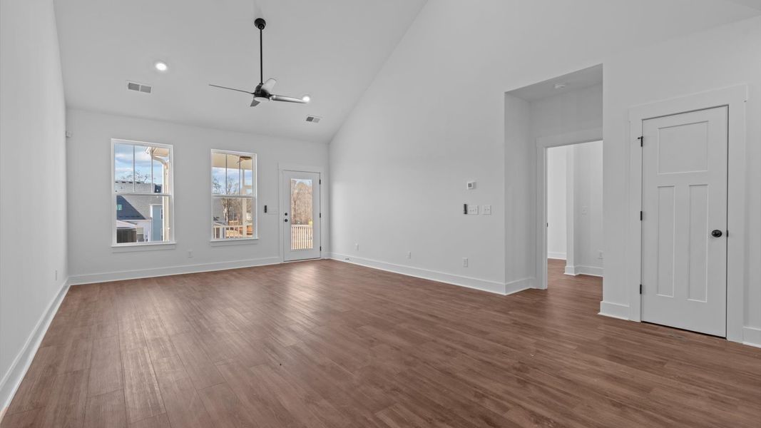 Spacious and stylish family room with two-story ceilings that create a bright and open atmosphere