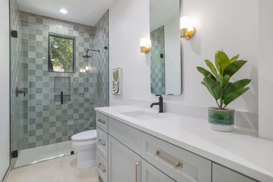 Modern bathroom featuring a walk-in shower with green checkered tile, a framed window, and a built-in niche