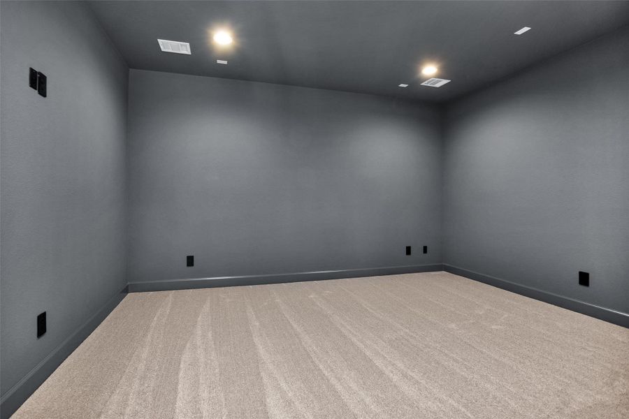 This dedicated media room is prewired for surround sound and features darkened walls and ceiling for the ultimate movie night experience.