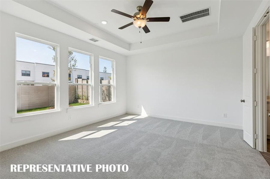 High ceilings, plush carpet and a wall of windows create a peaceful and relaxing owner's suite.  REPRESENTATIVE