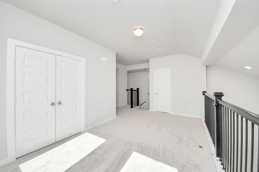 Ascend to relaxation in this fantastic game room! Ideal for both casual gatherings and adult gaming, it boasts plush carpet, lofty ceilings, custom paint, and ample windows for abundant natural light. Sample photo of completed home with similar floor plan. Actual colors and selections may vary.