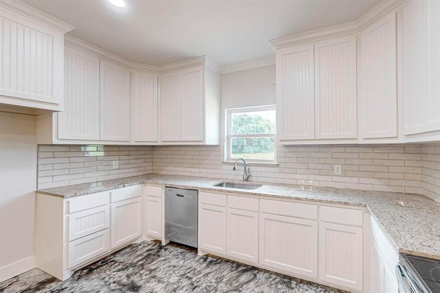 Kitchen featuring white cabinets, sink, and appliances with stainless steel finishes