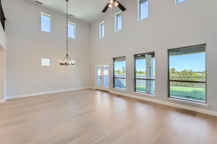 Unfurnished living room with a towering ceiling and plenty of natural light