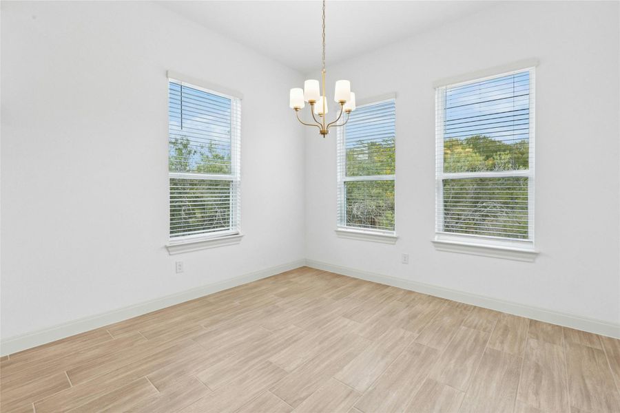 Unfurnished dining area with wood tiled floors and a chandelier Unfurnished dining area with wood tiled floors and a chandelier