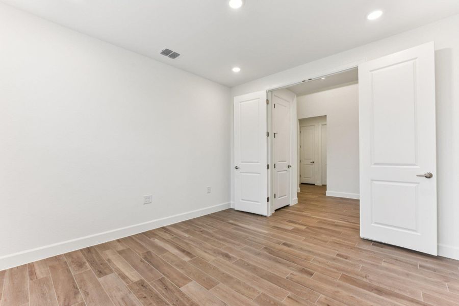 Unfurnished bedroom with light wood-style flooring and recessed lighting Unfurnished bedroom with light wood-style flooring and recessed lighting